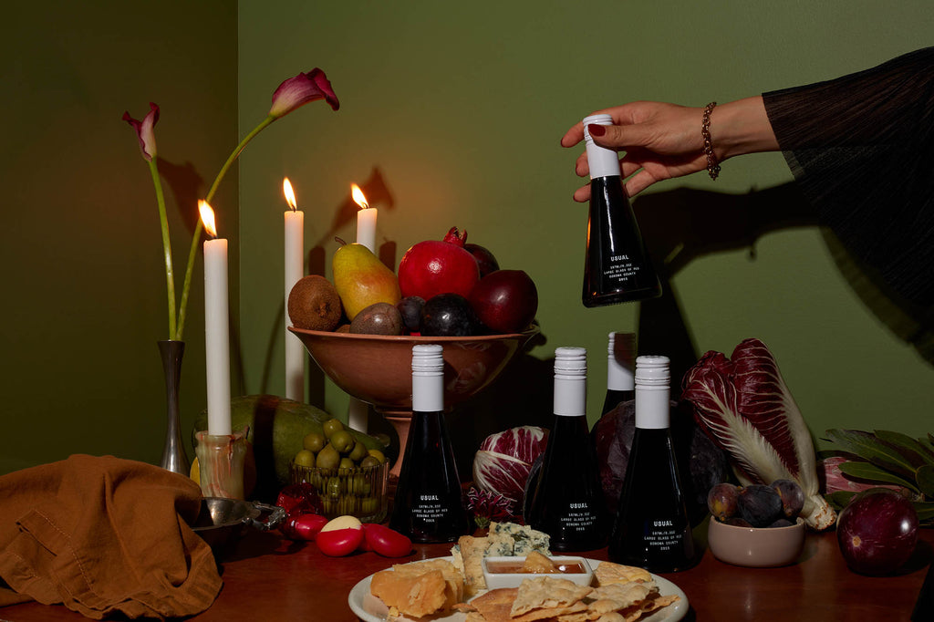 女人在桌子上拿着一个普通的葡萄酒瓶