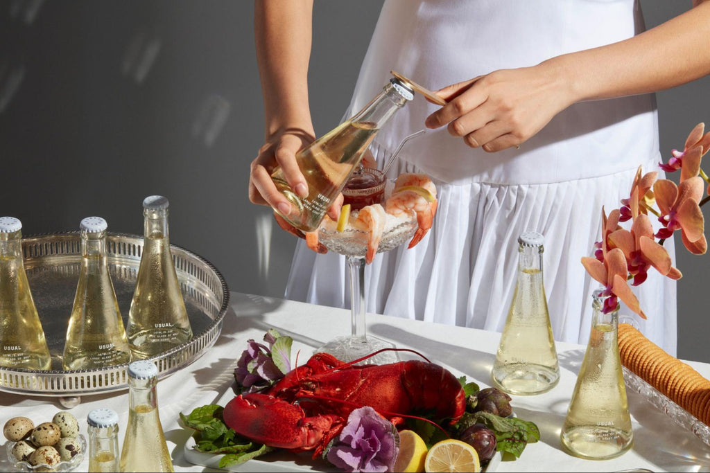 女人在桌子上打开一大瓶普通葡萄酒布鲁特，配上龙虾和虾鸡尾酒